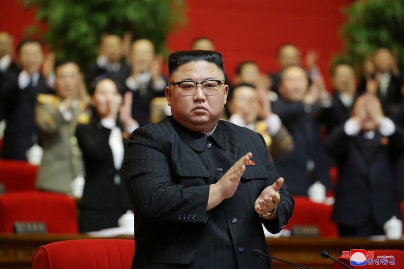 North Korean leader Kim Jong Un applauds at the 8th