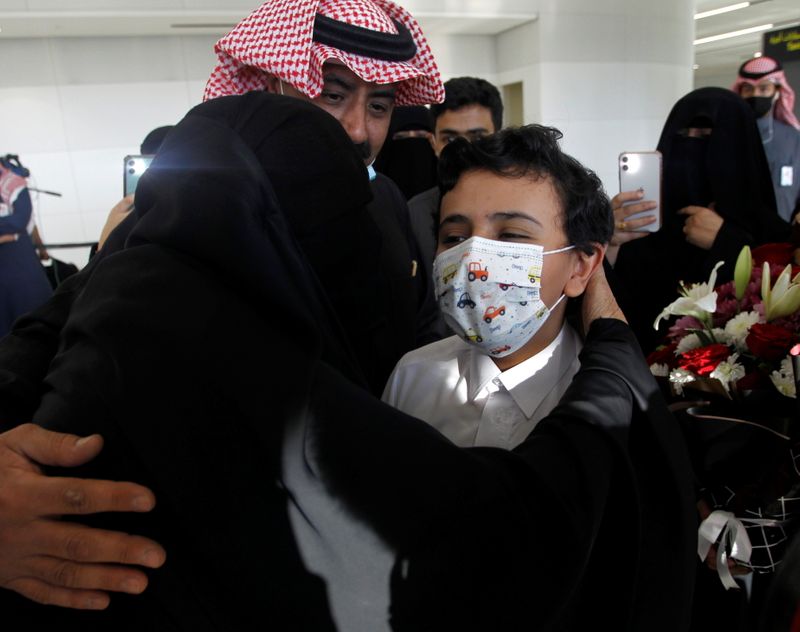 Woman hugs her relative who arrived from Doha, at King