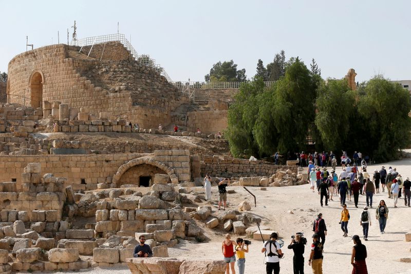 FILE PHOTO: Tourists walk next to ancient Roman landmarks during