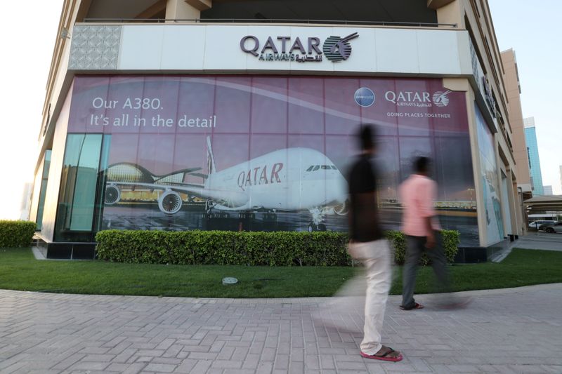 FILE PHOTO: FILE PHOTO: People walk past Qatar Airways office
