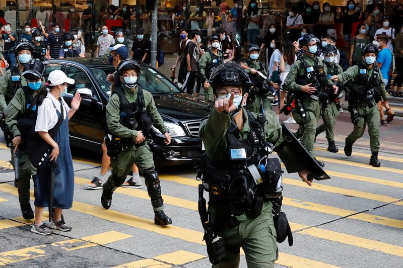 FILE PHOTO: Riot police chase pro-democracy protesters during a demonstration