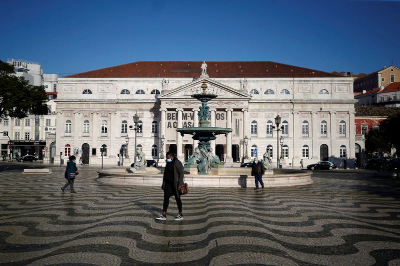 People walk by Rossio square on the first day of
