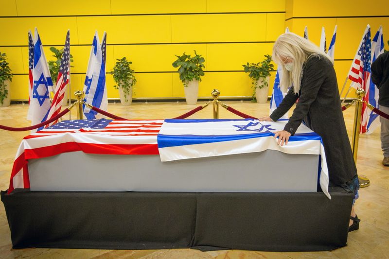 Miriam Adelson touches the casket of her husband, Sheldon Adelson