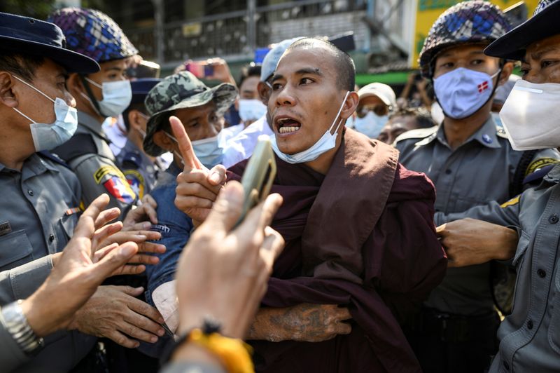 Police detain a Buddhist monk while he takes part in