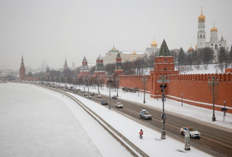 Cars drive along an embankment of the Moskva River near