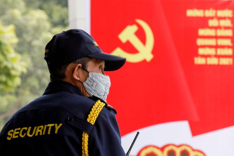 FILE PHOTO: A security officer stands guard near a poster