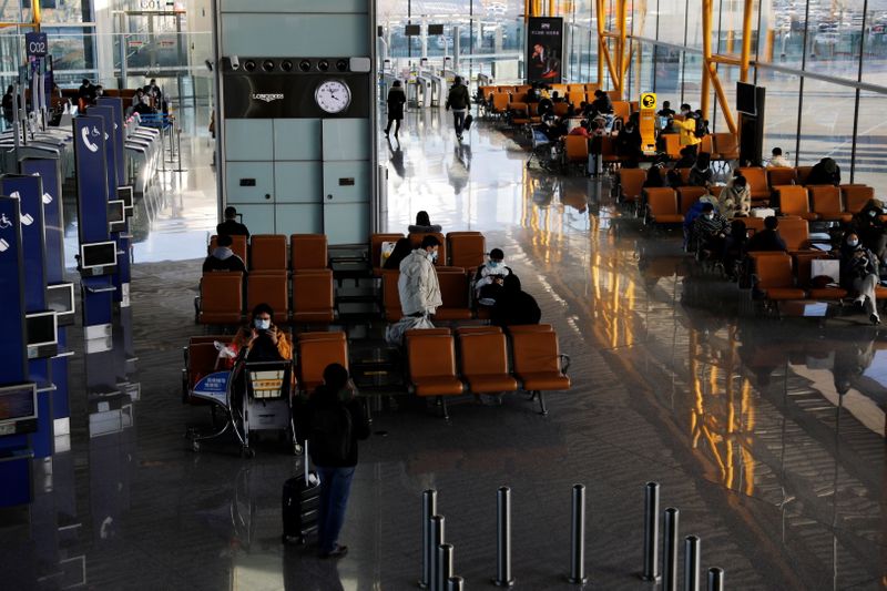 FILE PHOTO:  Travellers wait at Beijing Capital International Airport
