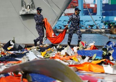 Indonesian navy personnel carry a body bag on the last