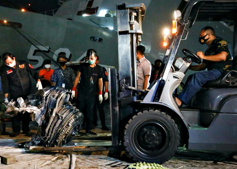Indonesia Navy personnel uses a forklift to move the turbine