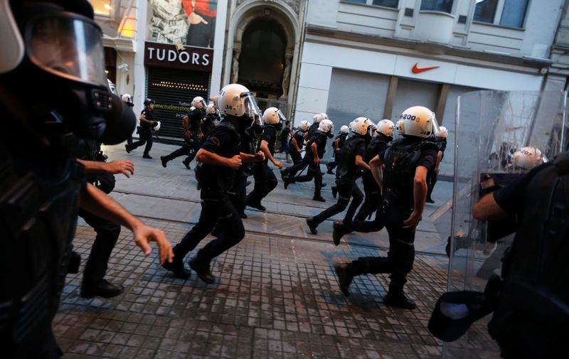 FILE PHOTO: Riot police officers run after demonstrators on Istiklal