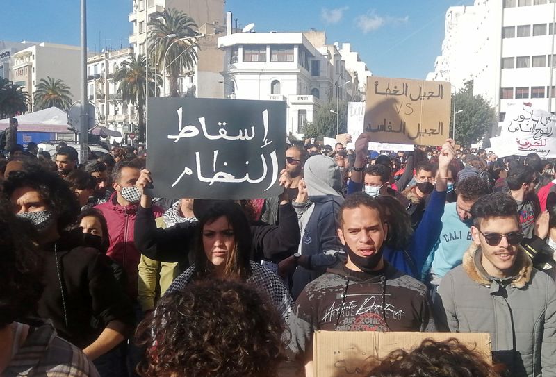 Demonstrators carry signs during an anti-government protest in Tunis