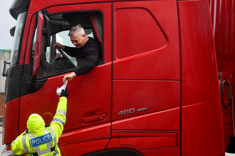 A police officer checks the documentation of a lorry driver