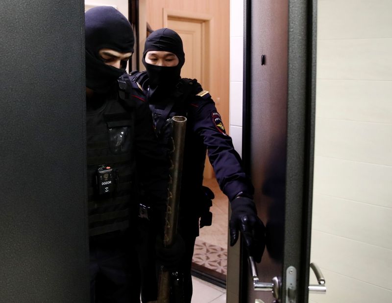 Law enforcement officers leave an apartment of Russian opposition leader