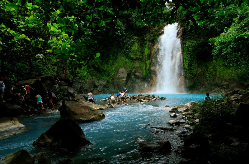 FILE PHOTO: People swim in the Celeste river waterfall at
