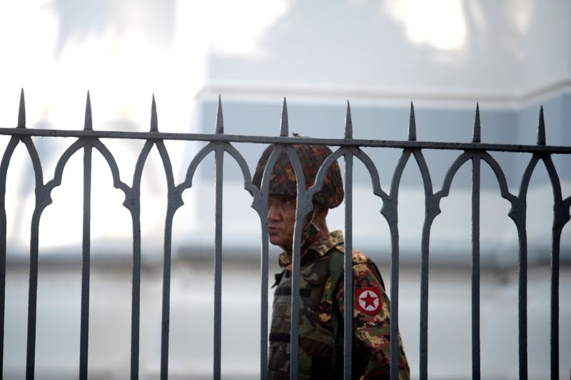 A Myanmar soldier looks on as he stands inside city