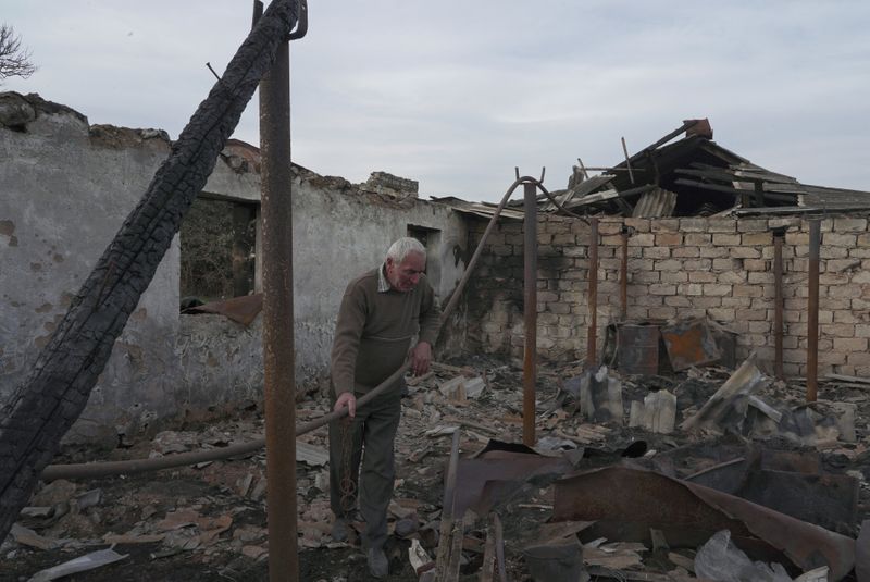 Local resident Lenser Gabrielyan stands on the ruins of his