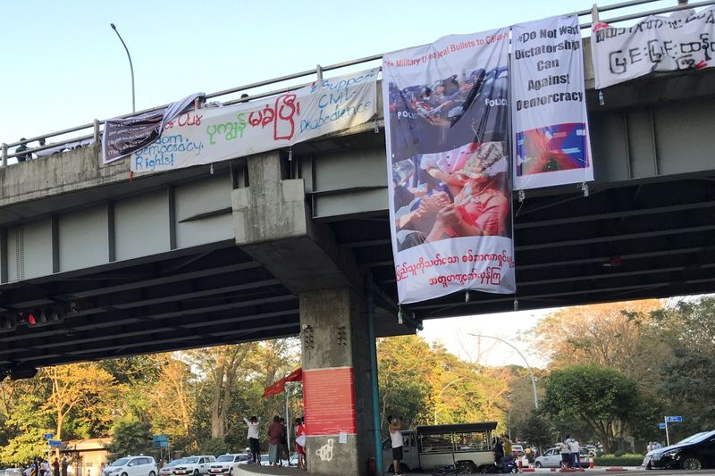 Banner hanging from a bridge shows a woman protester injured
