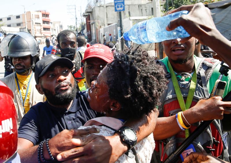 Journalists help a colleague who fainted after police threw tear