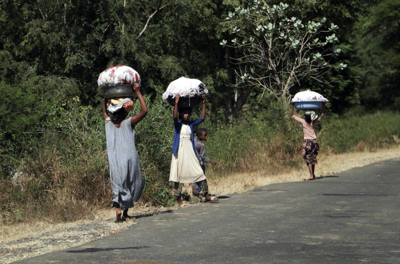 FILE PHOTO: Girls carry laundry in Soroka town in Amhara