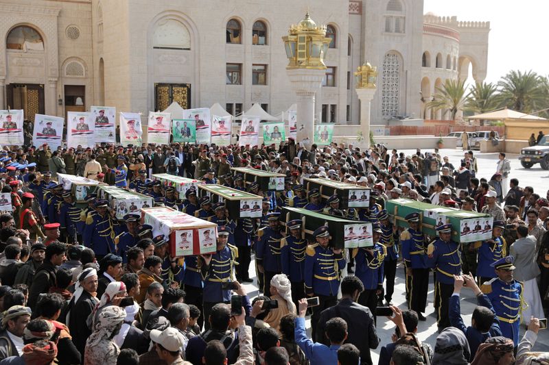 FILE PHOTO: Honour guards carry coffins of Houthi fighters killed