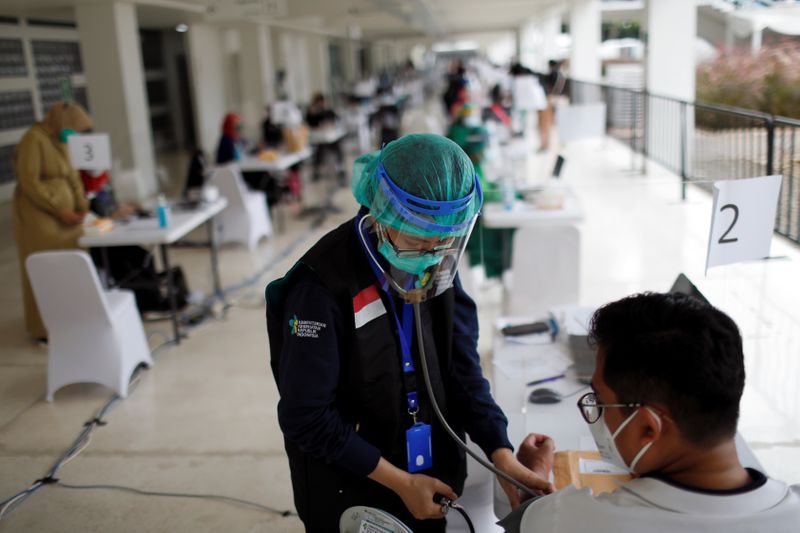 Healthcare worker performs a health screening during a mass vaccination