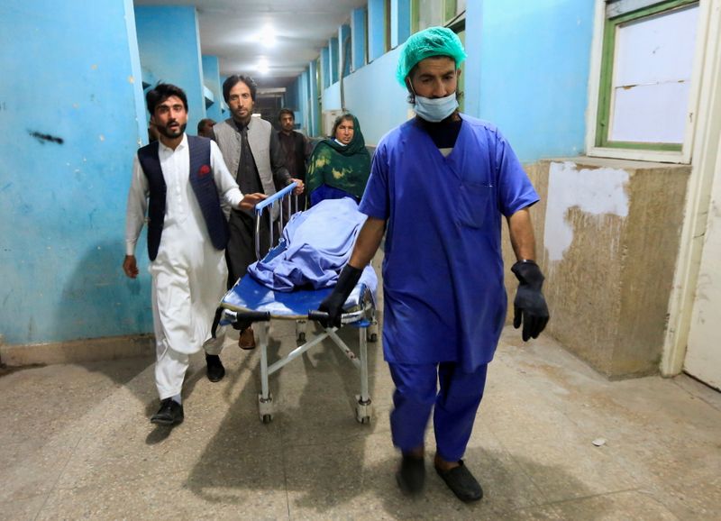 Afghan men transport the body of one of three media