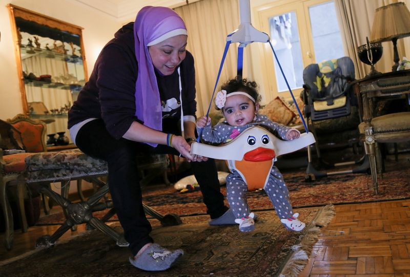 Yasmina al-Habbal, plays with Ghlaya, an orphan she sponsors, at