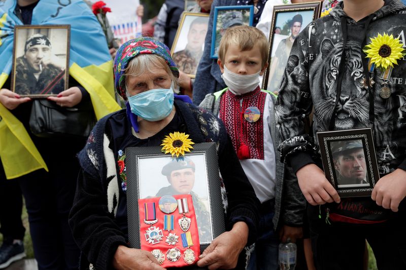 FILE PHOTO: Relatives hold portraits of servicemen, killed in conflict