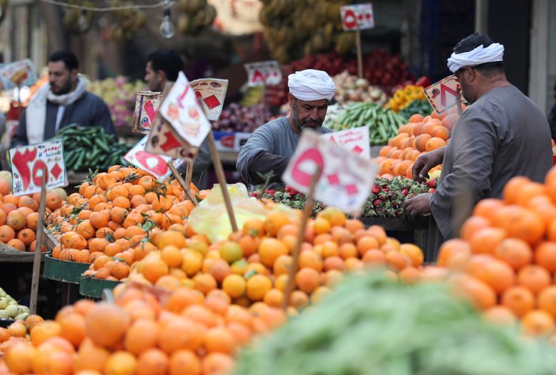 FILE PHOTO: Vendors work at a vegetable market amid the
