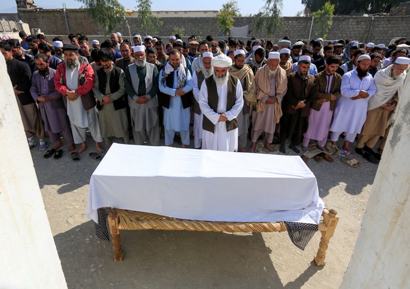 FILE PHOTO: Afghan men pray in front of the coffin