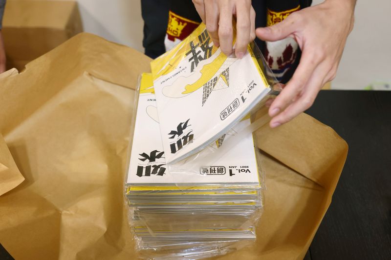 A staff prepares the Flow HK magazine to ship abroad