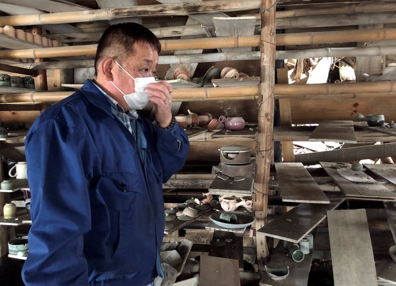 Toshiharu Onoda looks at his studio damaged by the March