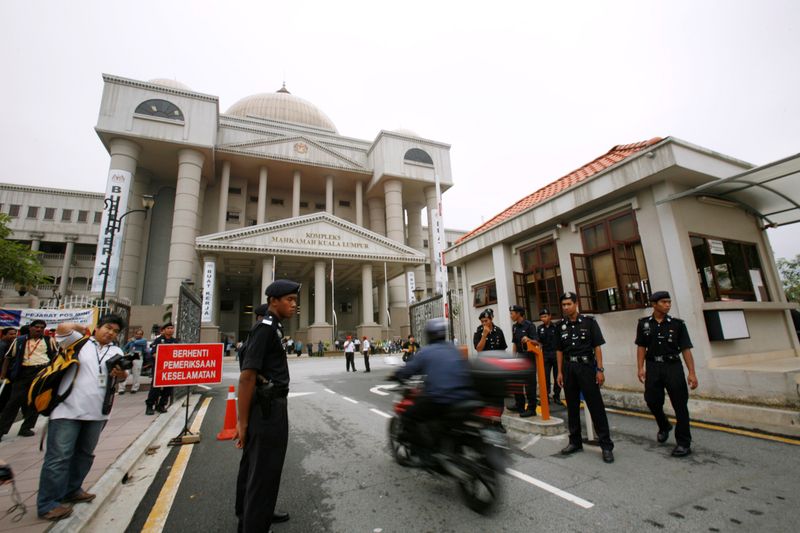 FILE PHOTO: Police monitor traffic at the entrance of Malaysia’s