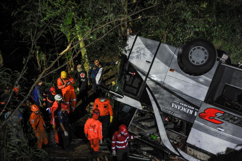 Rescue personnel work at the crash site after a bus