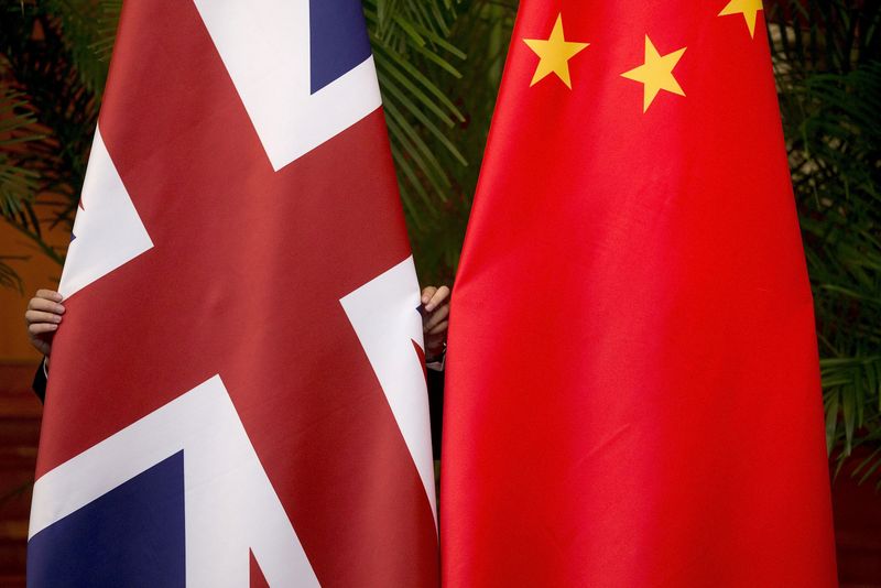 FILE PHOTO: A worker adjusts British and China national flags