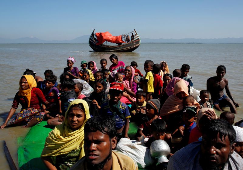 FILE PHOTO: Rohingya refugees sit on a makeshift boat as