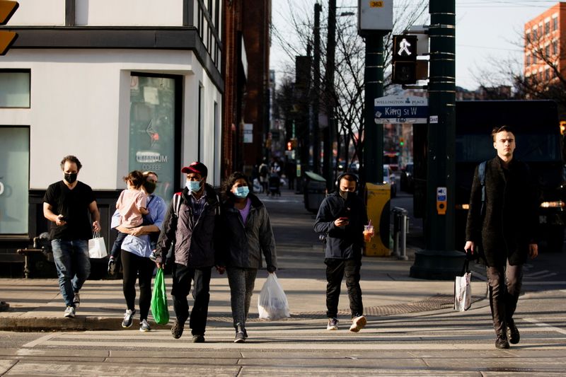 People walk with face masks in Toronto