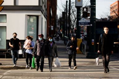 People walk with face masks in Toronto