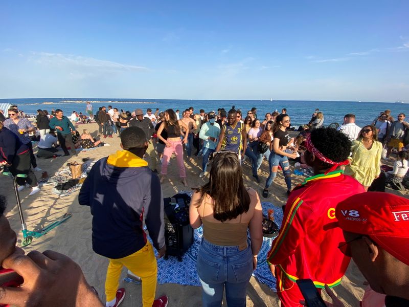 People dance at Barceloneta beach, in Barcelona
