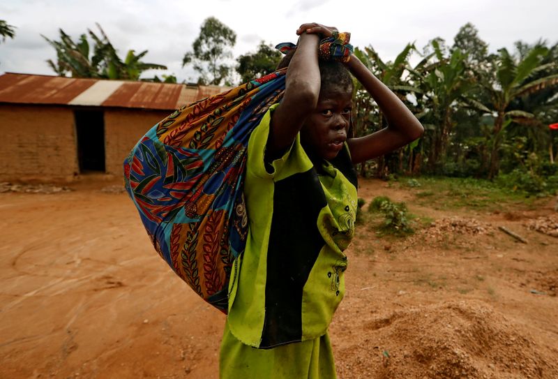 FILE PHOTO: A girl carries cassava leaves on her back