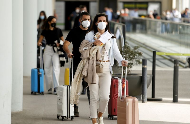 Passengers wearing protective face masks arrive at Son Sant Joan