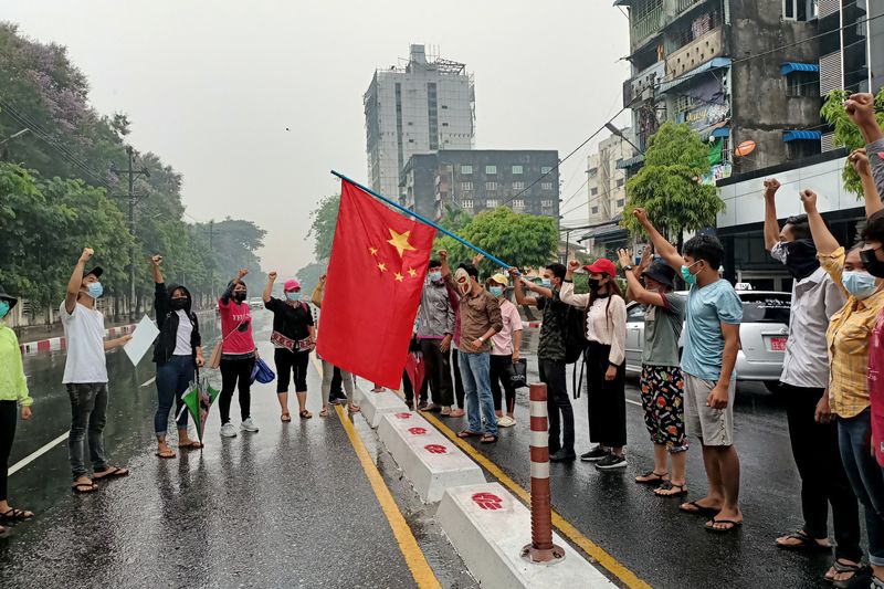 FILE PHOTO: Anti-coup protesters hold Chinese flag in Yangon