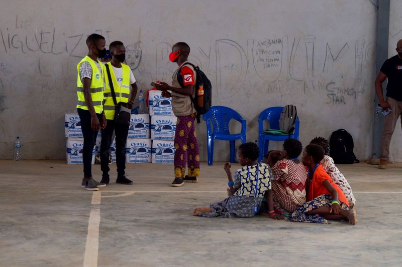 People look on as aid workers consult a person at