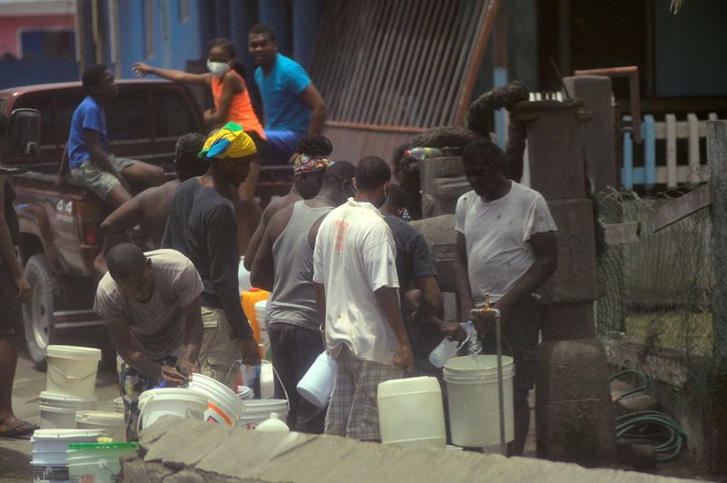 Local residents fill containers of water after a series of