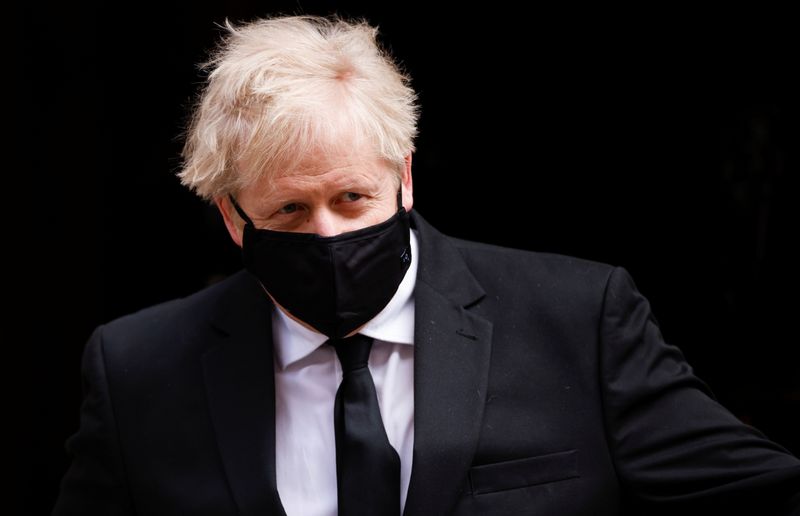 Britain’s PM Johnson walks outside Downing Street, in London