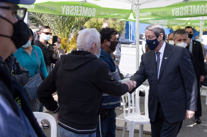 Cypriot President Nicos Anastasiades greets a citizens during a visit