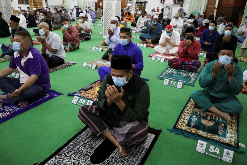 Muslims wearing protective face masks offer Eid al-Adha prayers at