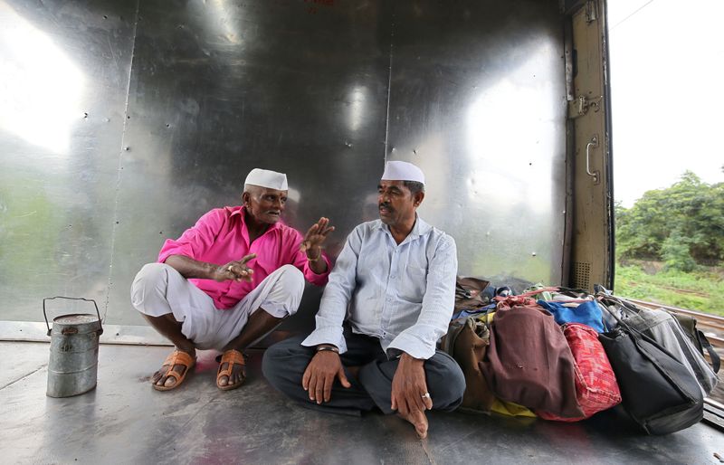 Dabbawalas, also known as tiffin carriers, wearing traditional caps travel