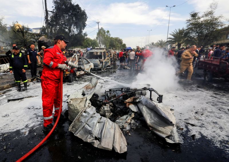 FILE PHOTO: A firefighter inspects the site of a car