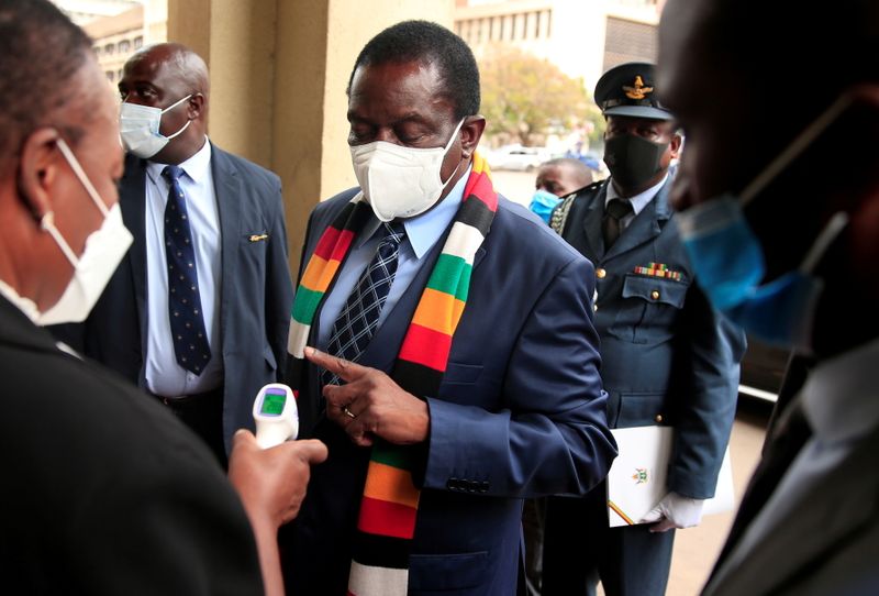 FILE PHOTO: Zimbabwe’s President Mnangagwa has his temperature taken as